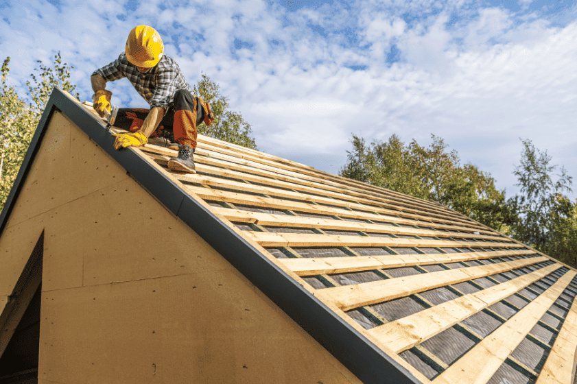 Roofer inspecting residential roof, assessing roof age and condition for homeowners insurance in Florida.