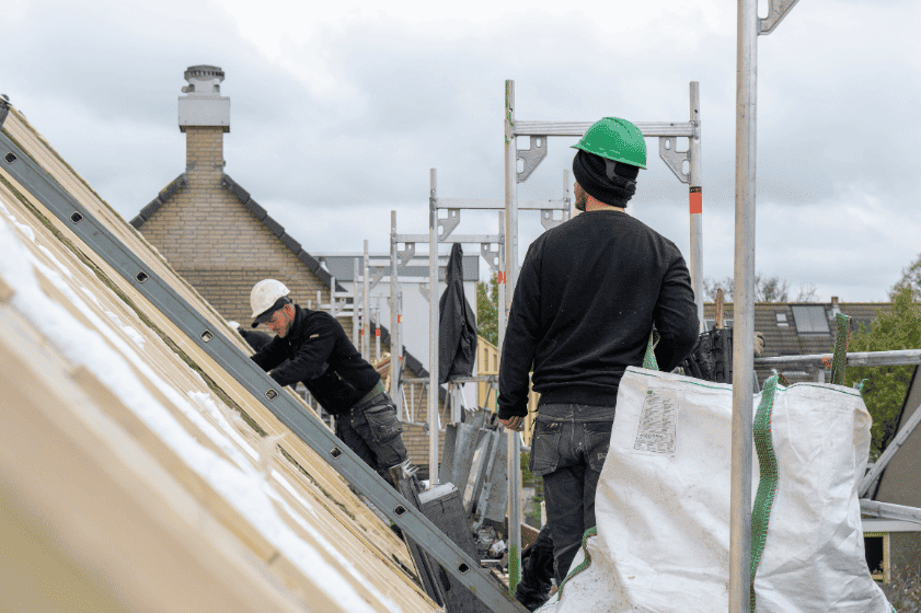 Roofers working on a residential roof in Windermere, Florida, illustrating roof schedules and homeowners insurance coverage.
