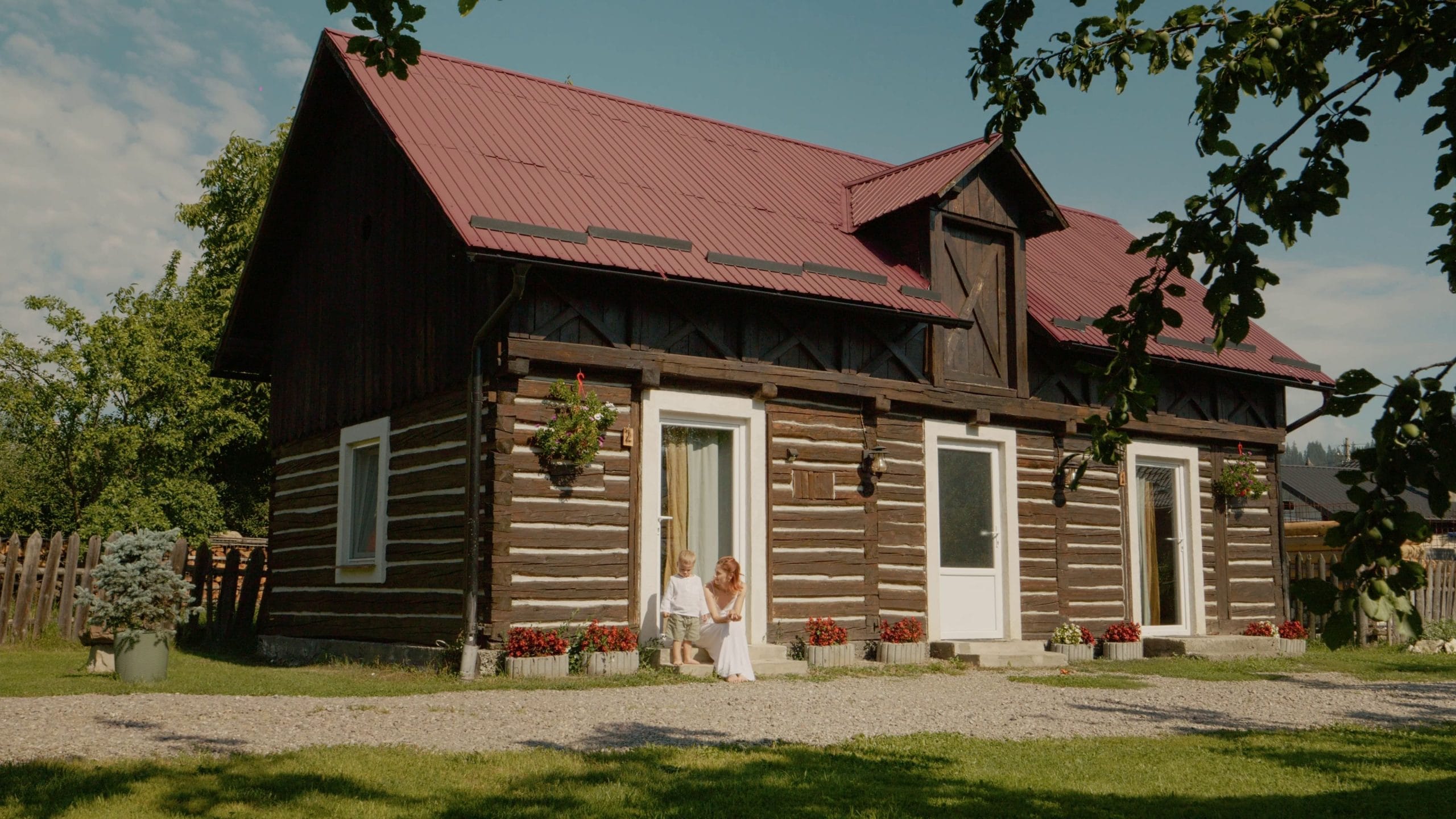 a woman and her little boy spend time outside a traditional house in bucovina they enj SBI 357247061 scaled